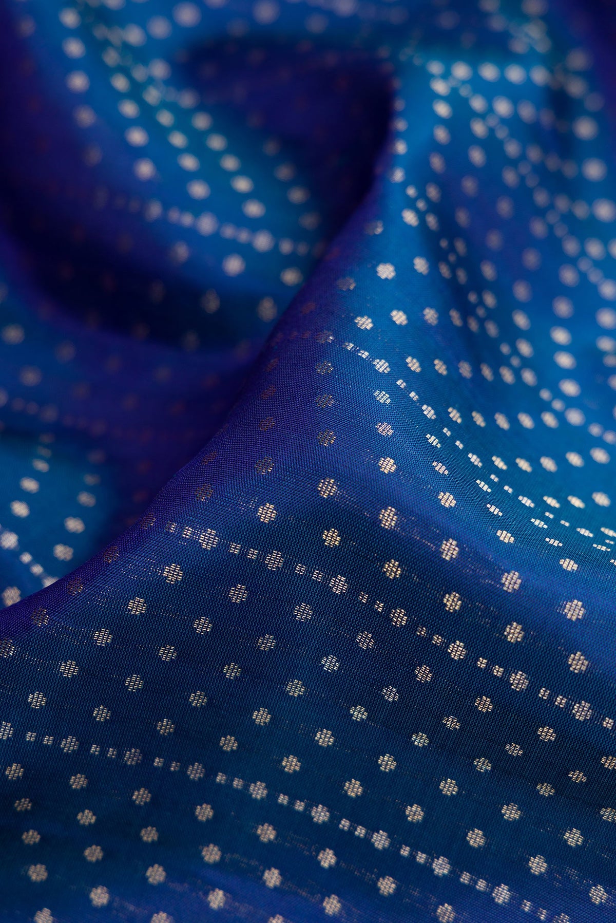 Close up of Peacock Blue Dual Tone Soft Silk Saree with Zari Butta on the body and Zari Border.  displaying folds