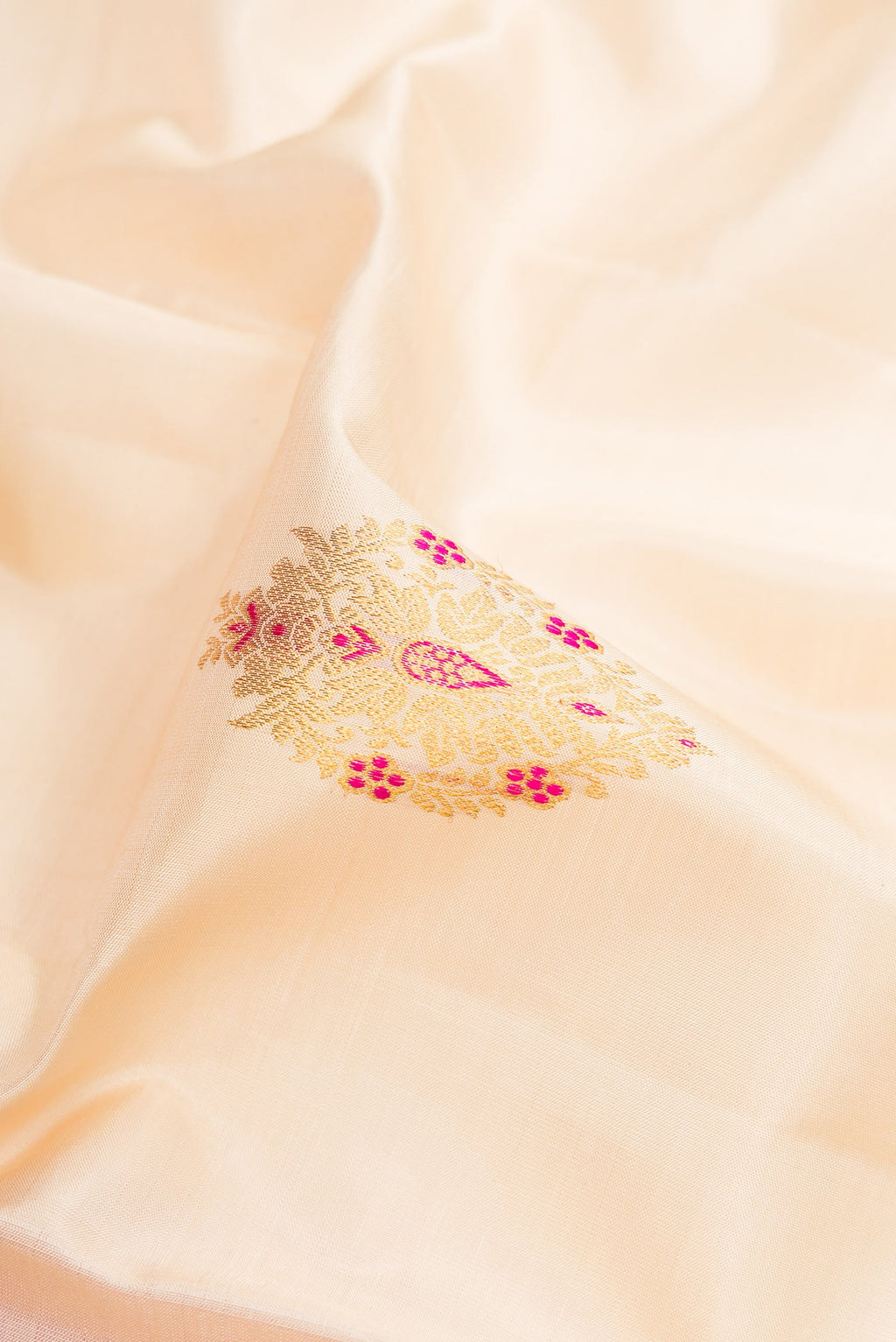 Close up of Off White Kanchipuram Silk Saree with Zari And Thread Butta on the body and Zari Border.  displaying folds