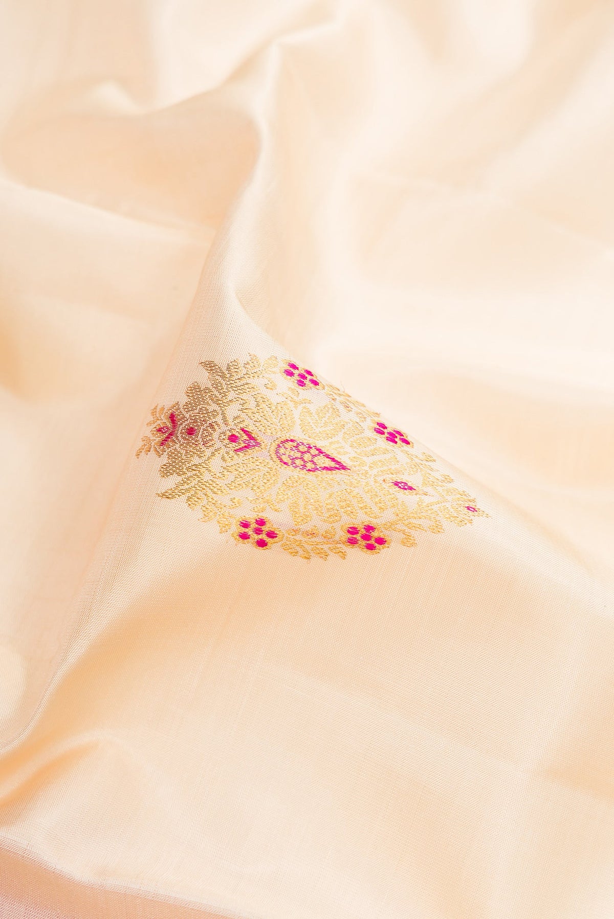 Close up of Off White Kanchipuram Silk Saree with Zari And Thread Butta on the body and Zari Border.  displaying folds