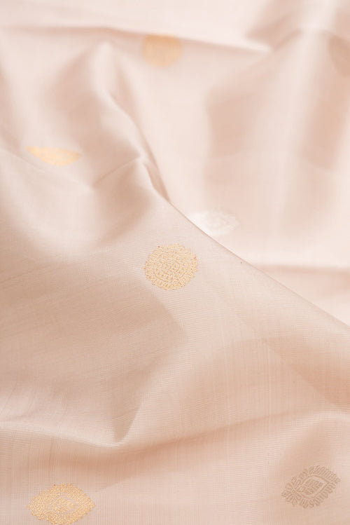 Close up of Beige Dual Tone Kanchipuram Silk Saree with Zari Butta on the body and Zari And Thread Border.  displaying folds