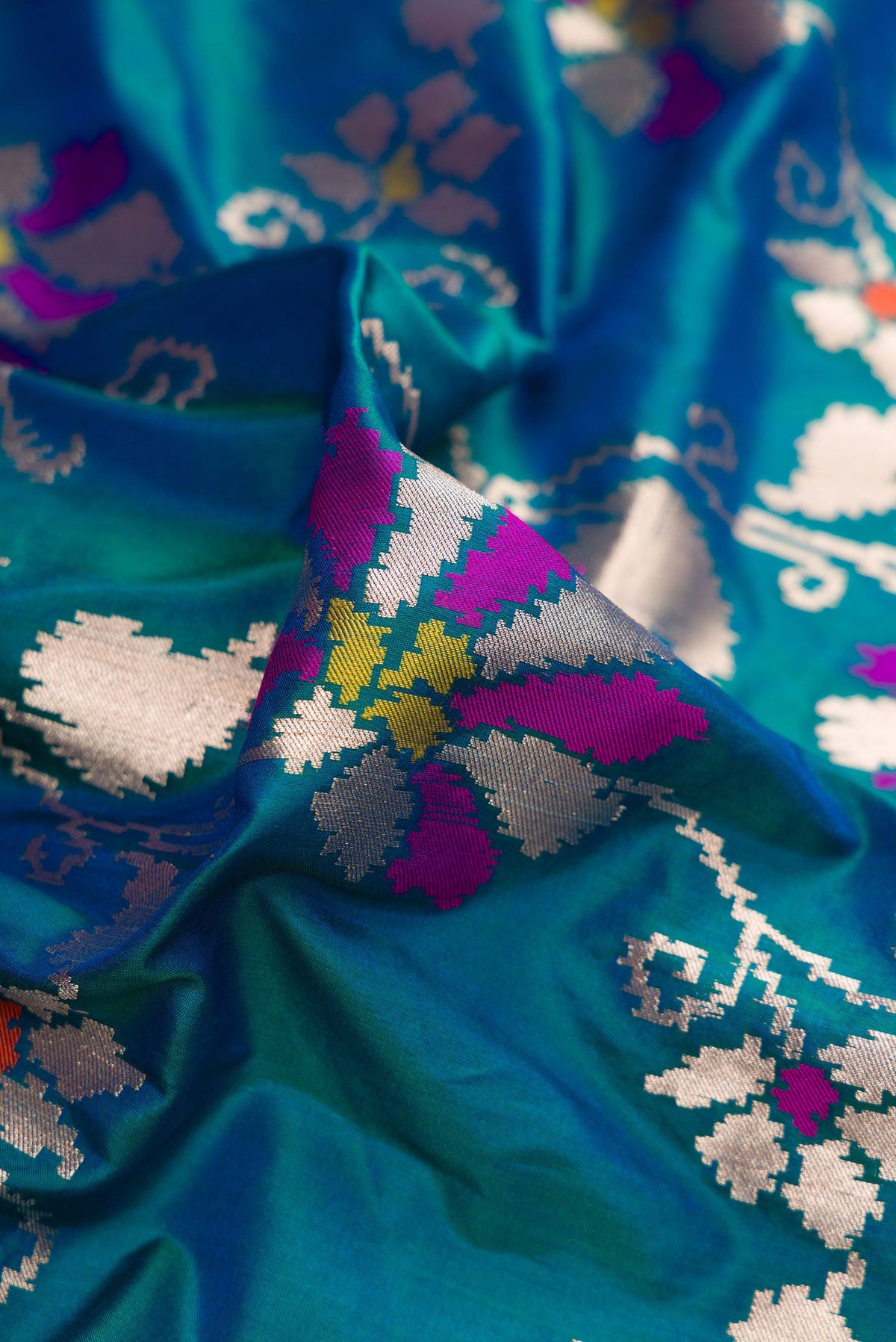 Close up of Peacock Blue Dual Tone Banarasi Silk Saree with Zari Butta on the body and Zari Border.  displaying folds
