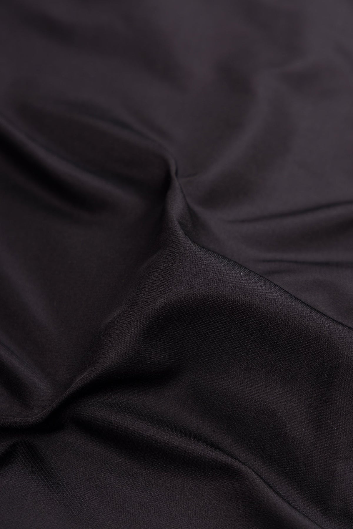 Close up of Black Banarasi Silk Saree with Plain Body and Zari Border.  displaying folds
