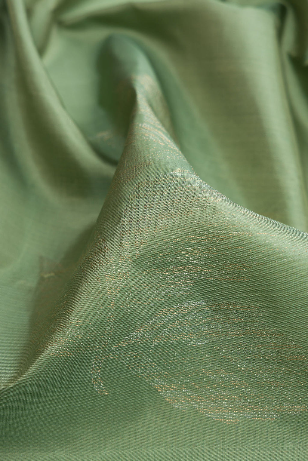 Close up of Pista Green Soft Silk Saree with Zari Butta on the body and Without Border.  displaying folds