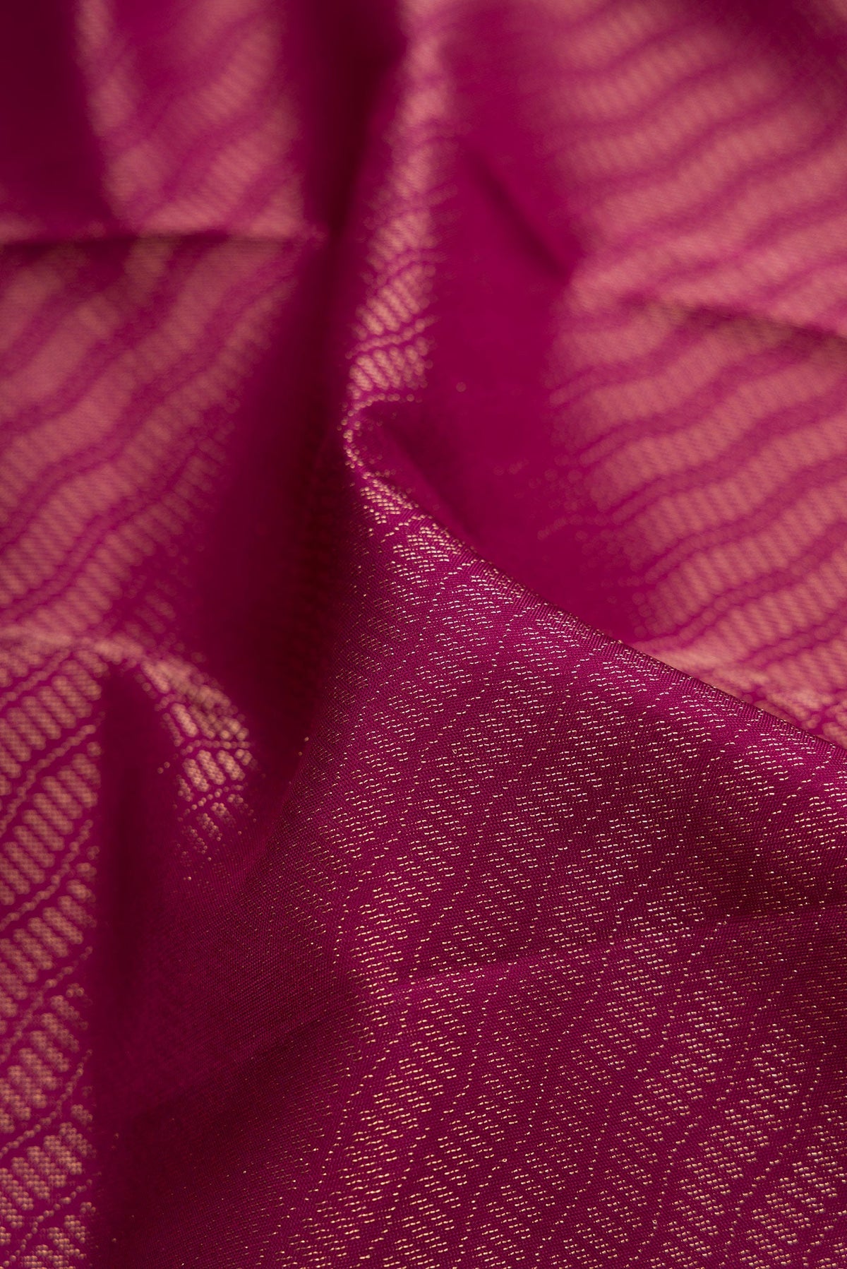 Close up of Magenta Soft Silk Saree with Zari Brocade on the body and Fancy Border.  displaying folds
