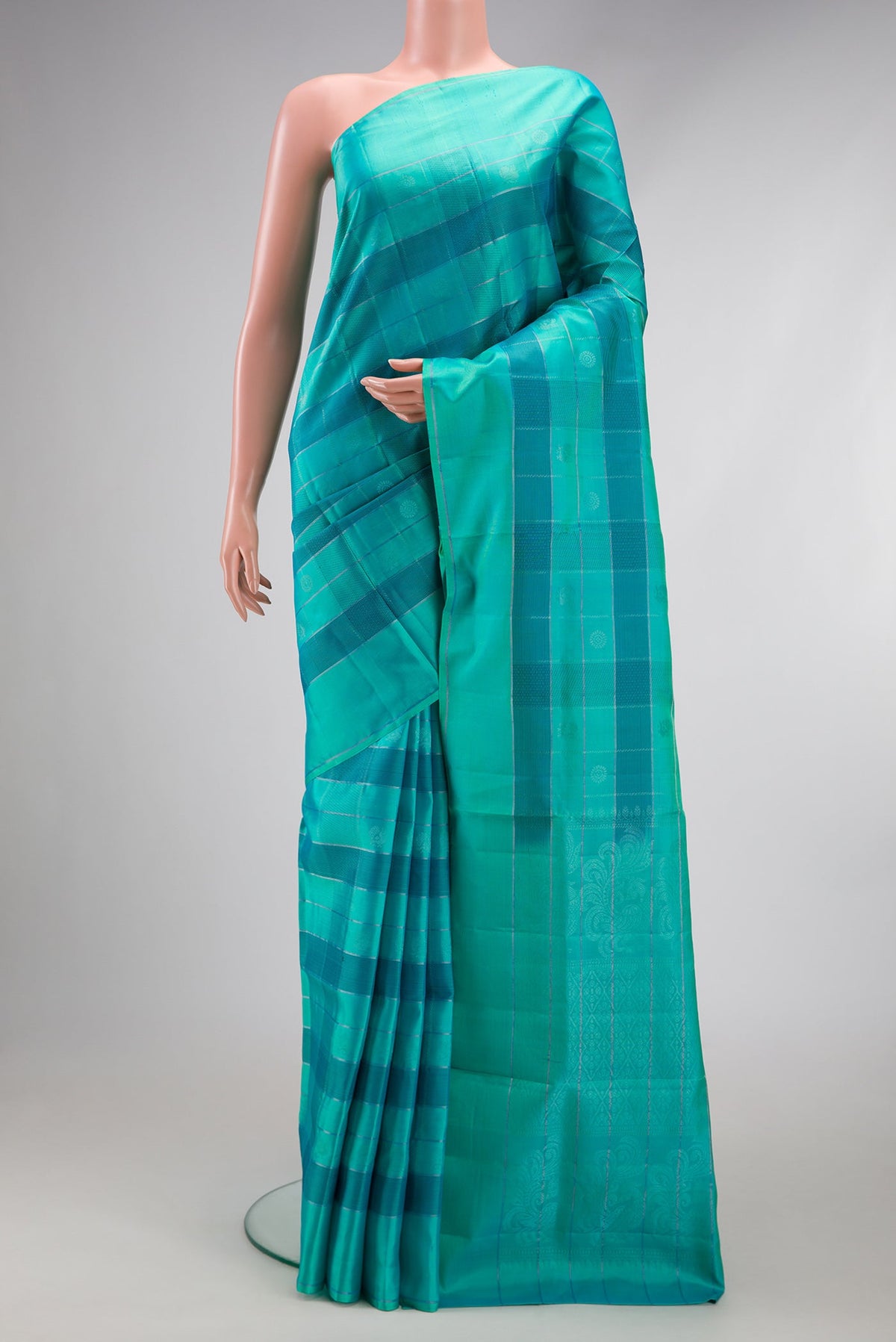 Sea Green Soft Silk Saree with Checked design on the body and Plain Border.  displayed on a mannequin
