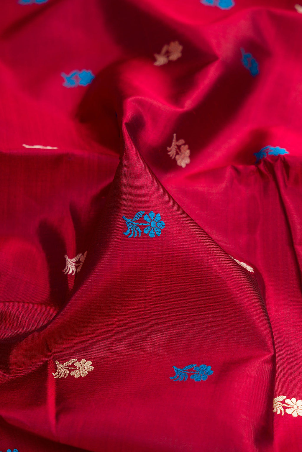 Close up of Maroon Dual Tone Baluchari Silk Saree with Thread Butta on the body and Thread Border.  displaying folds