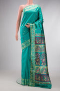 Turquoise Baluchari Silk Saree with Thread Butta on the body and Thread Border.  displayed on a mannequin