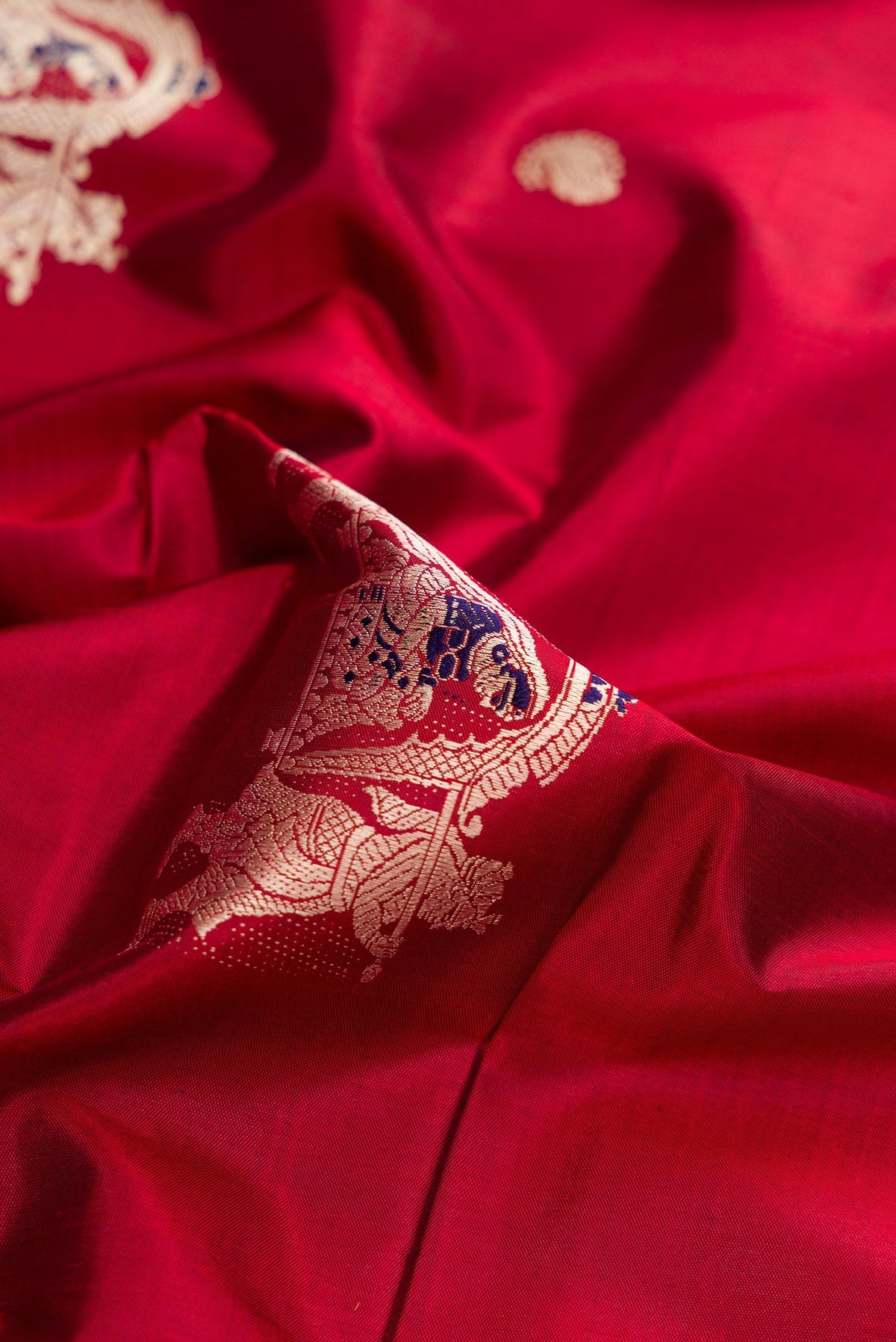 Close up of Maroon Baluchari Silk Saree with Thread Butta on the body and Thread Border.  displaying folds