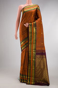 Rust Kanjivaram Silk Saree with Zari Butta on the body and Zari Border.  displayed on a mannequin